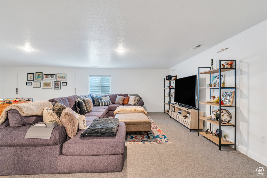 Living area featuring baseboards and light carpet