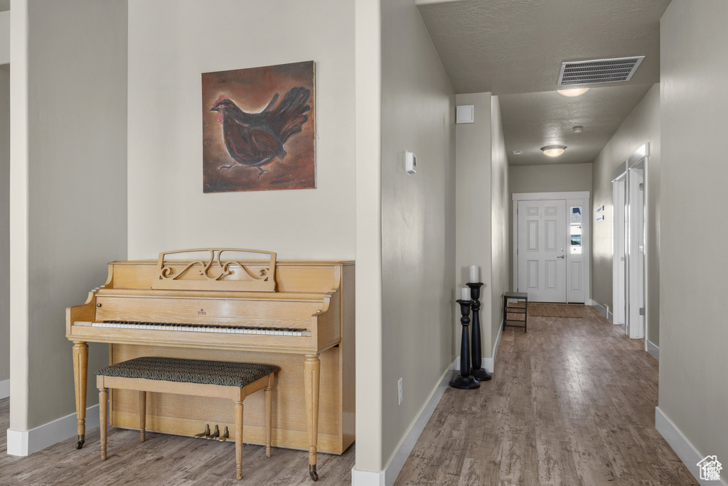 Hall featuring visible vents, baseboards, and wood finished floors