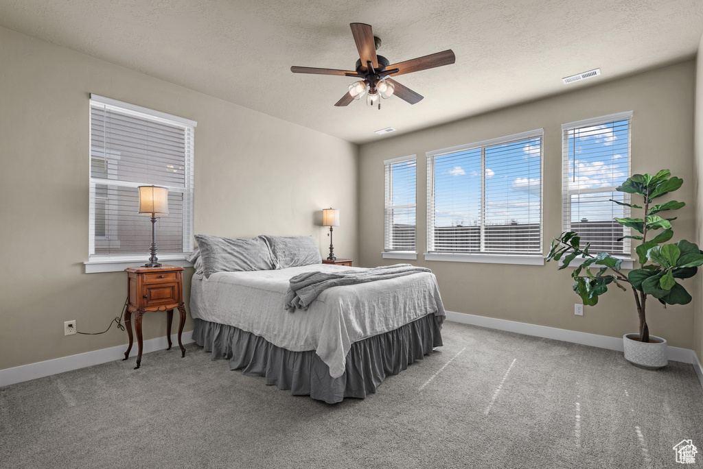 Bedroom featuring carpet flooring, baseboards, visible vents, and ceiling fan