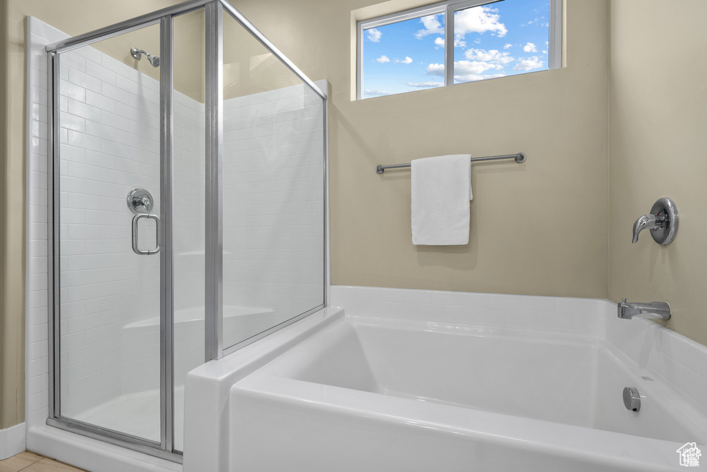Bathroom featuring a shower stall and a bath