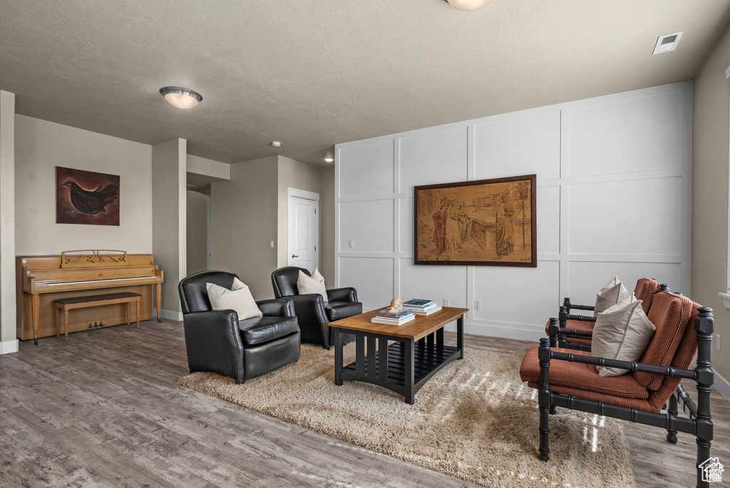 Living area featuring baseboards, wood finished floors, and visible vents