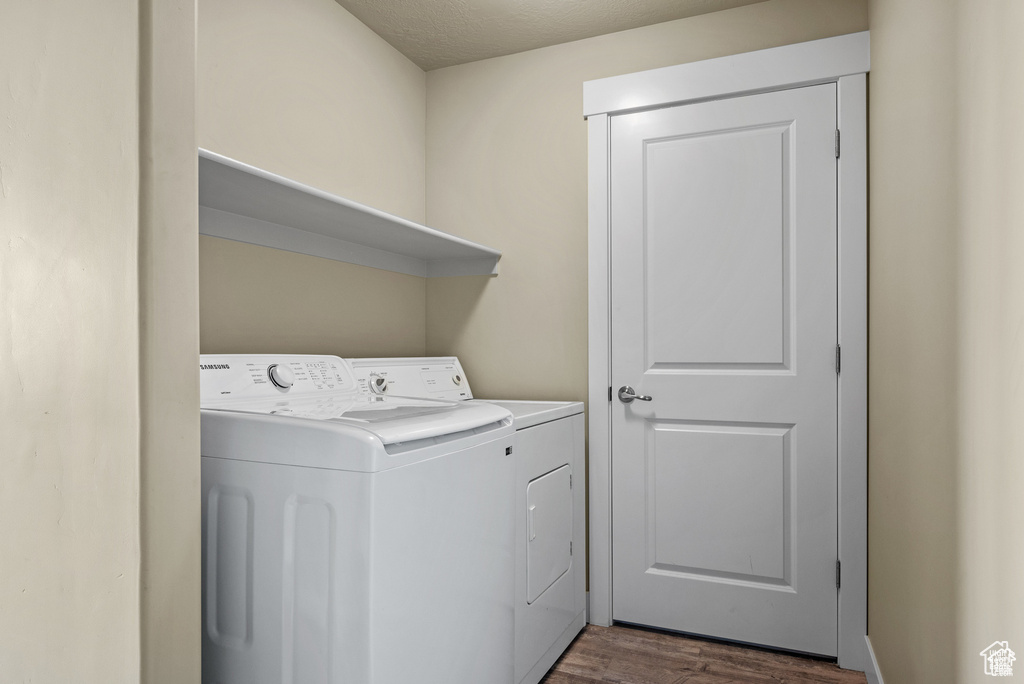 Laundry room with laundry area, dark wood-style flooring, and washer and clothes dryer