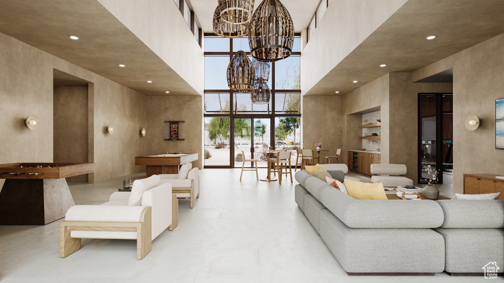 Living area with recessed lighting, a chandelier, and a towering ceiling