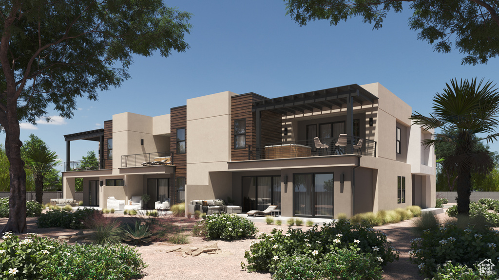 Rear view of property with a patio area, stucco siding, and a balcony