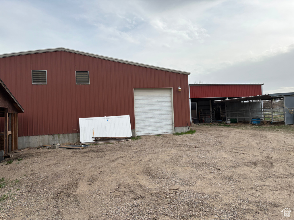 View of pole building with dirt driveway