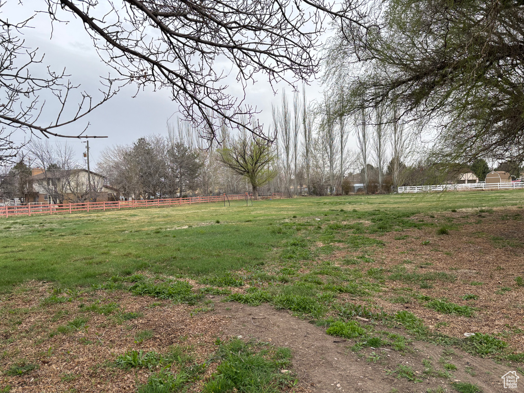 View of yard with fence and a rural view