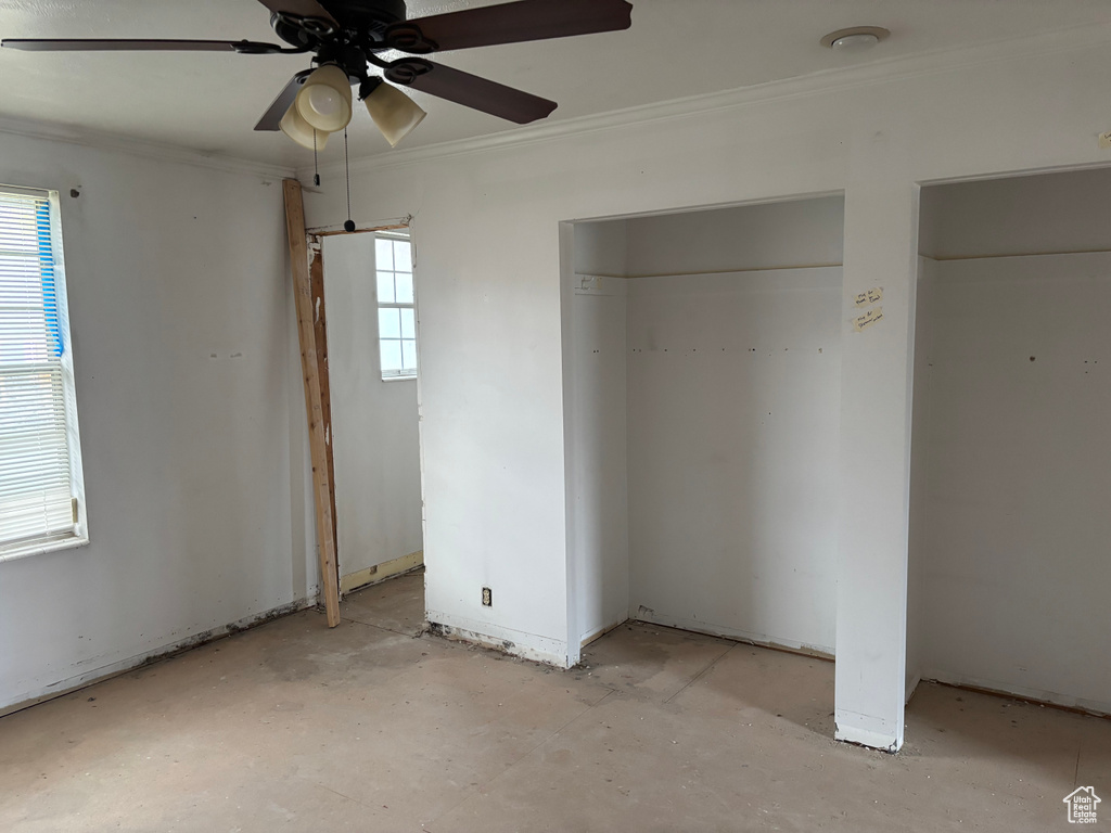 Unfurnished bedroom with crown molding, multiple windows, and ceiling fan