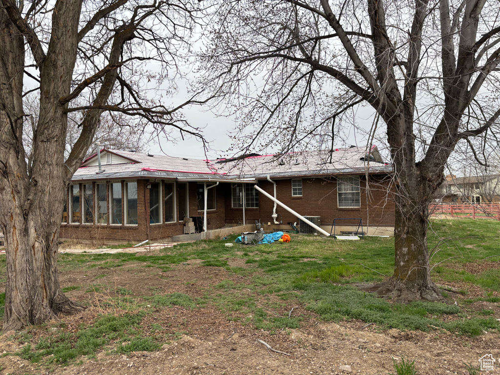 Back of house with brick siding and a sunroom