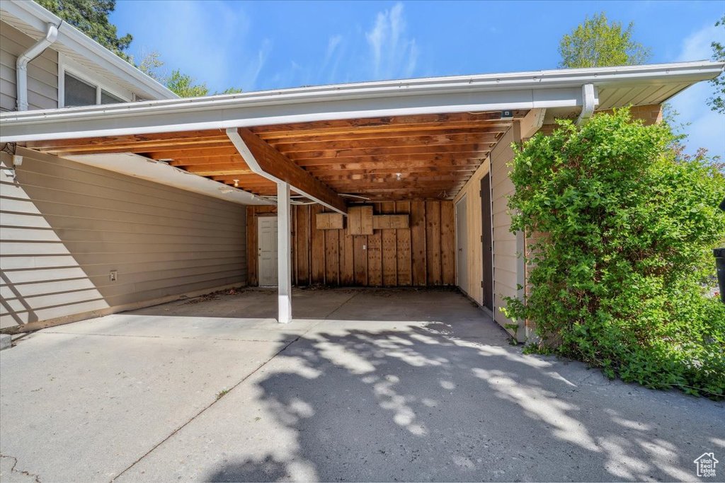 View of parking / parking lot with a carport and concrete driveway