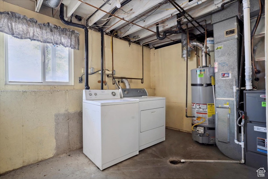 Washroom featuring secured water heater, laundry area, and washer and clothes dryer
