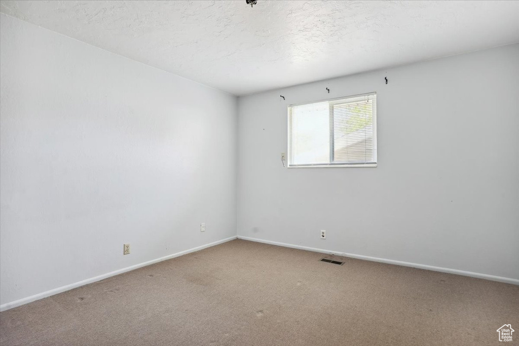 Unfurnished room featuring baseboards, carpet flooring, and visible vents