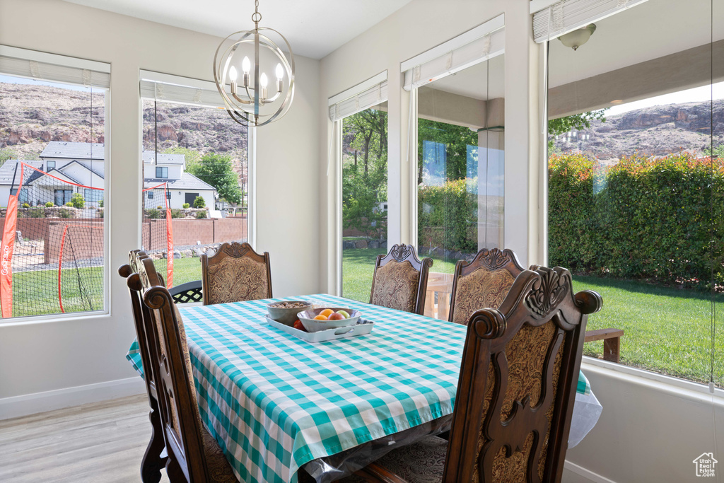 Dining space featuring baseboards, wood finished floors, and a notable chandelier