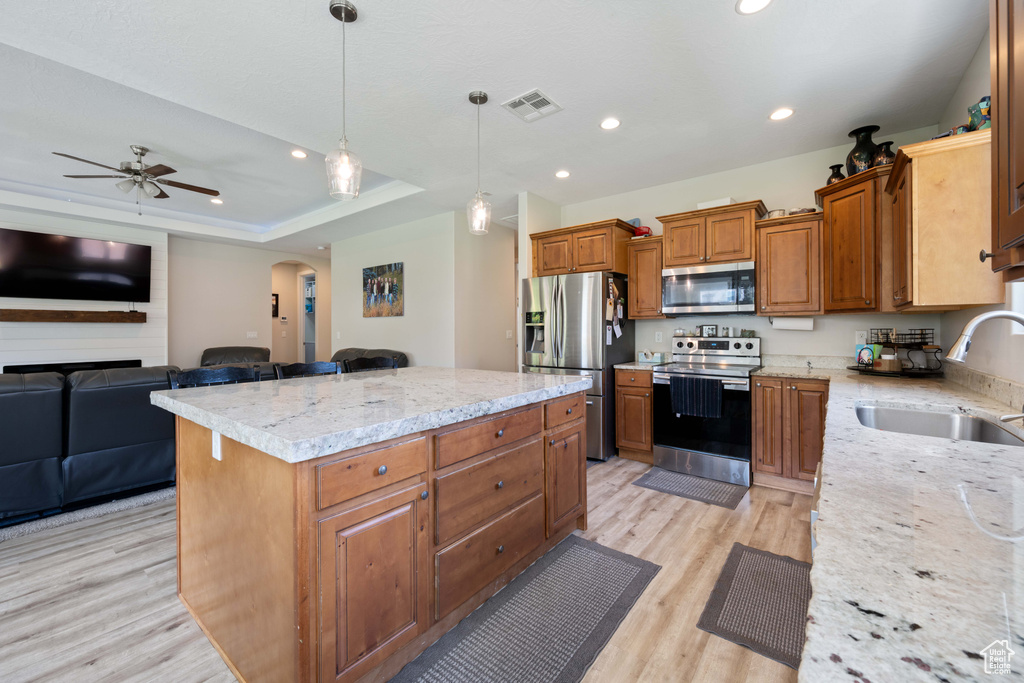 Kitchen featuring visible vents, arched walkways, a sink, light wood finished floors, and appliances with stainless steel finishes