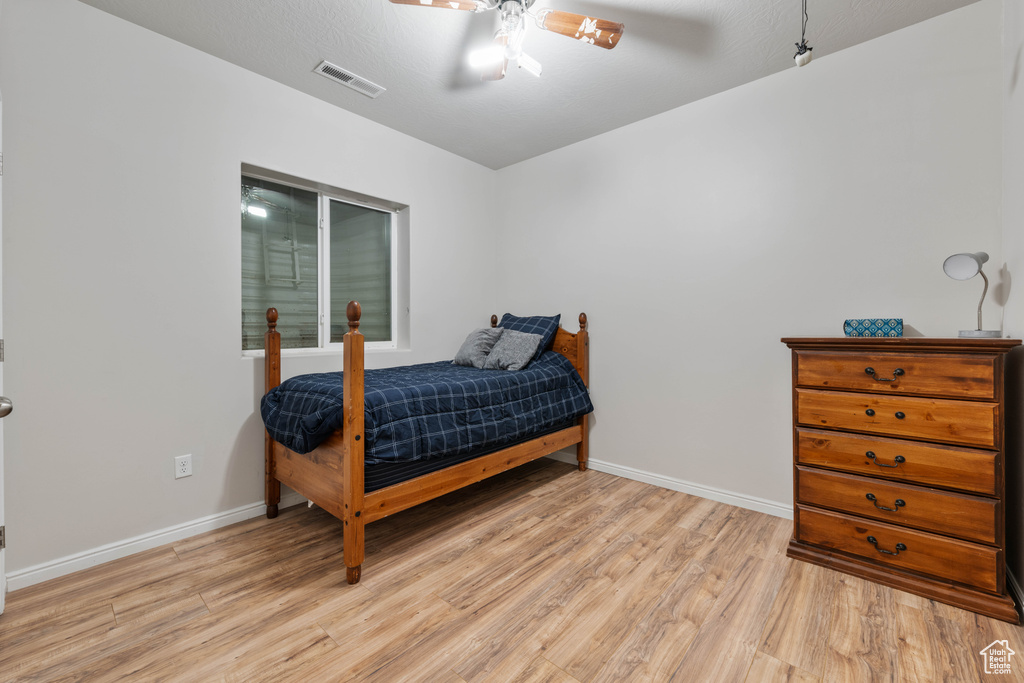 Bedroom featuring baseboards, visible vents, ceiling fan, and light wood-type flooring