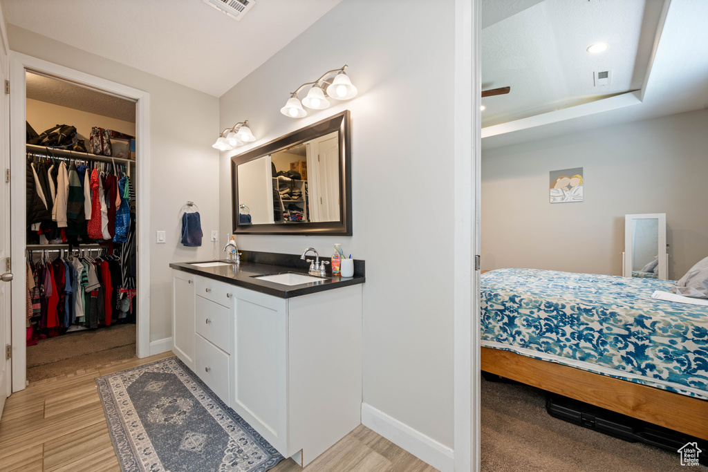Full bathroom featuring vanity, recessed lighting, wood finished floors, and a spacious closet