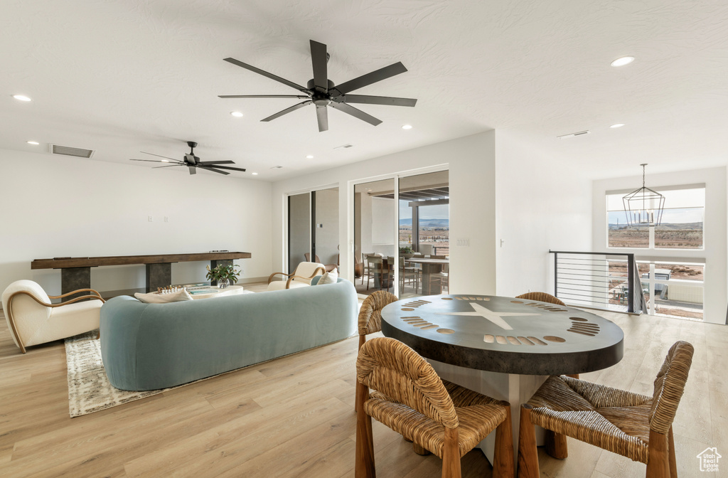 Interior space with light wood-type flooring, a ceiling fan, visible vents, and recessed lighting