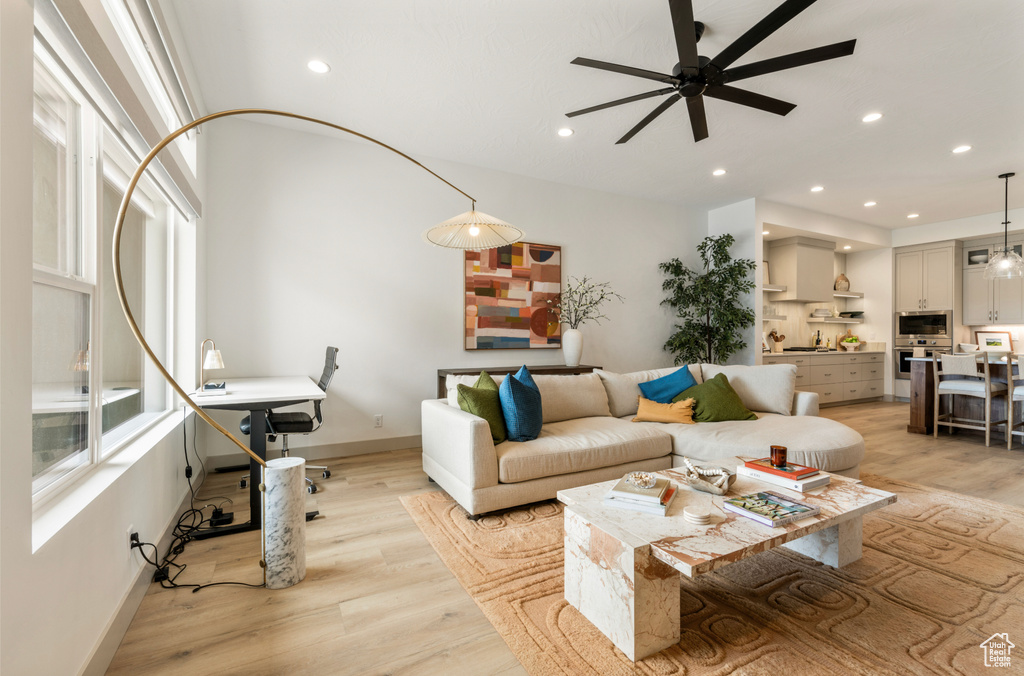 Living room with recessed lighting, baseboards, ceiling fan, and light wood-type flooring