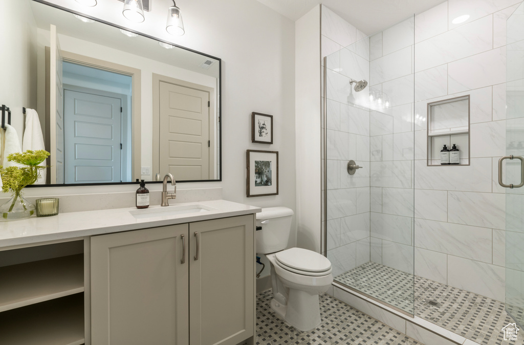 Full bathroom featuring vanity, a stall shower, and toilet