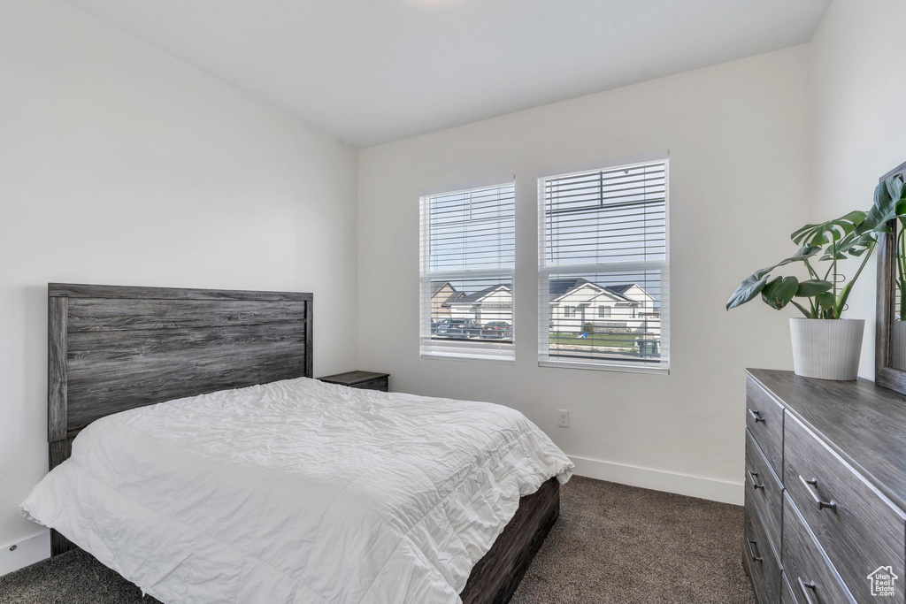 Bedroom with baseboards and dark colored carpet