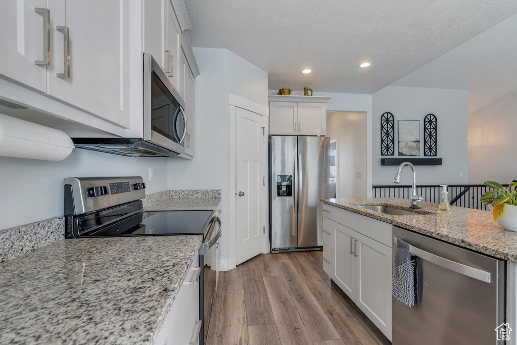 Kitchen featuring a sink, stainless steel appliances, recessed lighting, and white cabinetry
