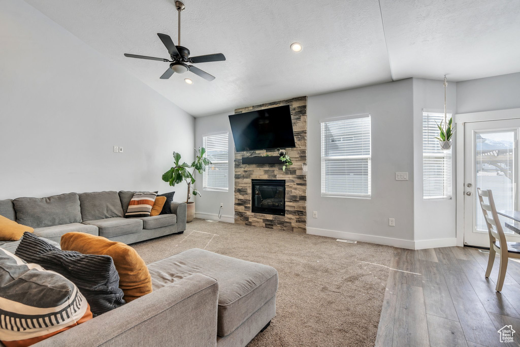 Living room featuring baseboards, plenty of natural light, a fireplace, and ceiling fan