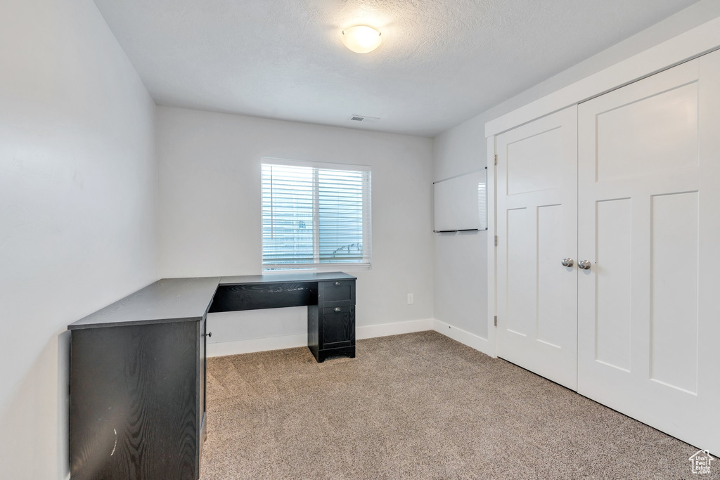 Unfurnished office with carpet flooring, baseboards, and visible vents
