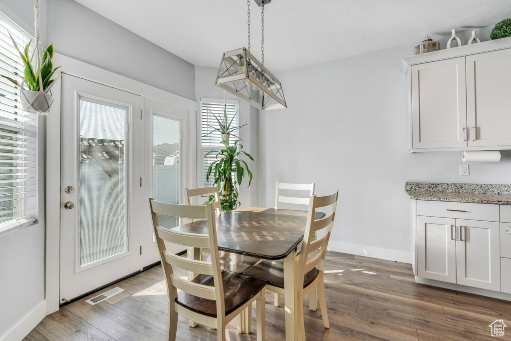 Dining area with baseboards, wood finished floors, and visible vents
