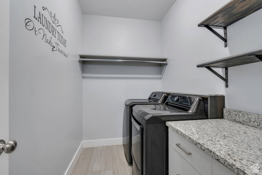 Laundry room with separate washer and dryer and baseboards