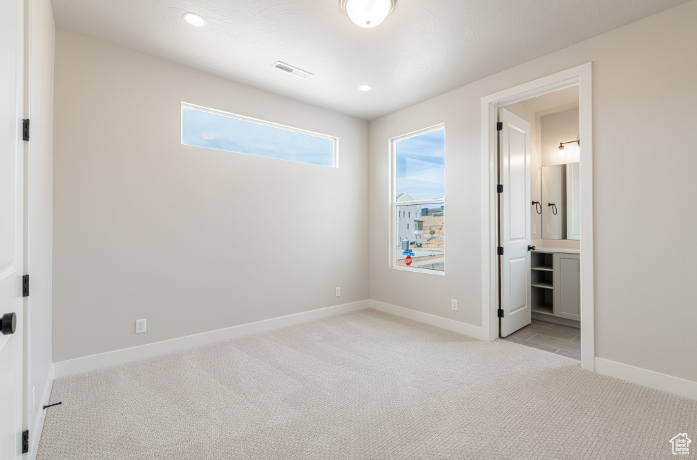 Unfurnished bedroom with recessed lighting, baseboards, light colored carpet, and visible vents