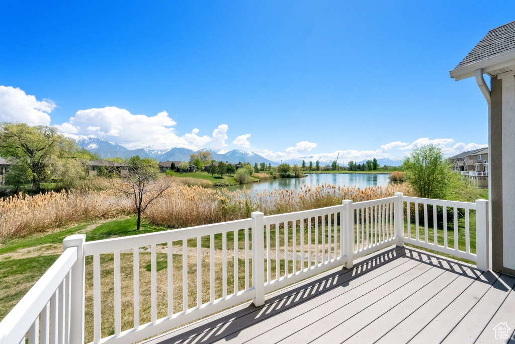 Wooden terrace with a lawn and a water and mountain view