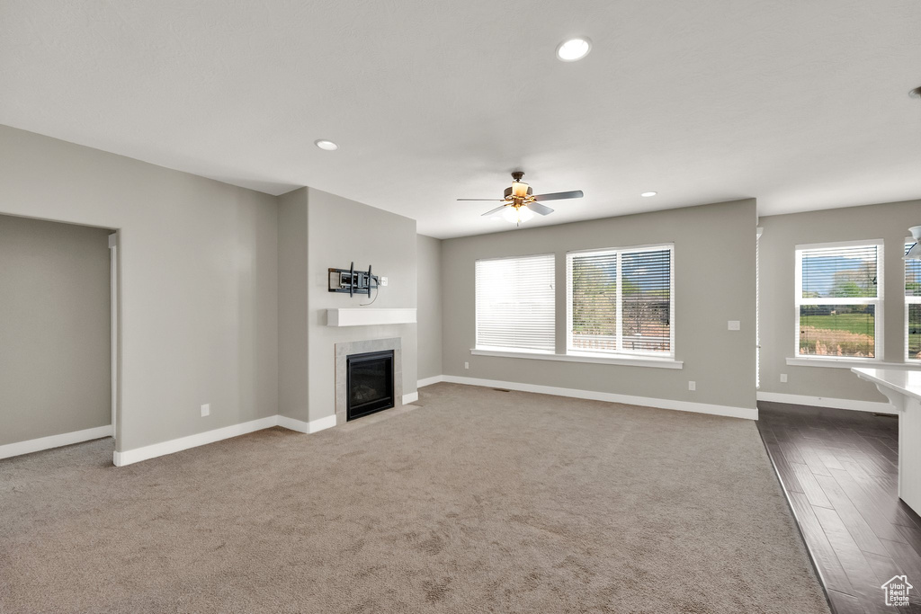 Unfurnished living room featuring baseboards, a ceiling fan, recessed lighting, and a tile fireplace
