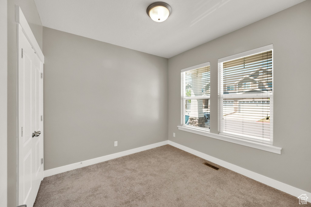 Spare room featuring baseboards, carpet flooring, and visible vents