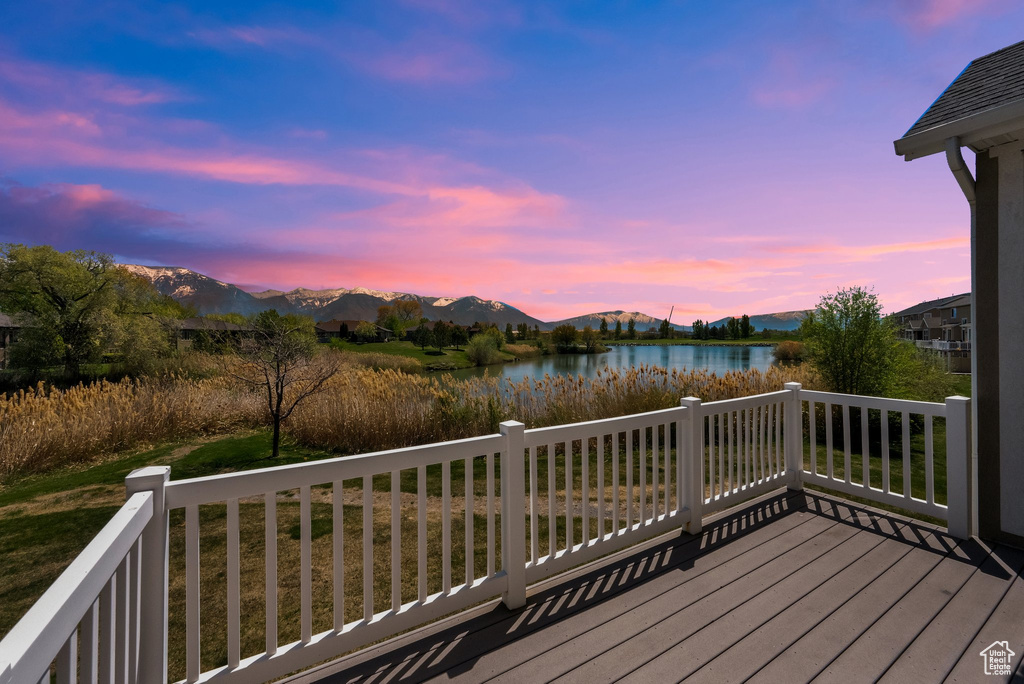 Deck at dusk with a water and mountain view