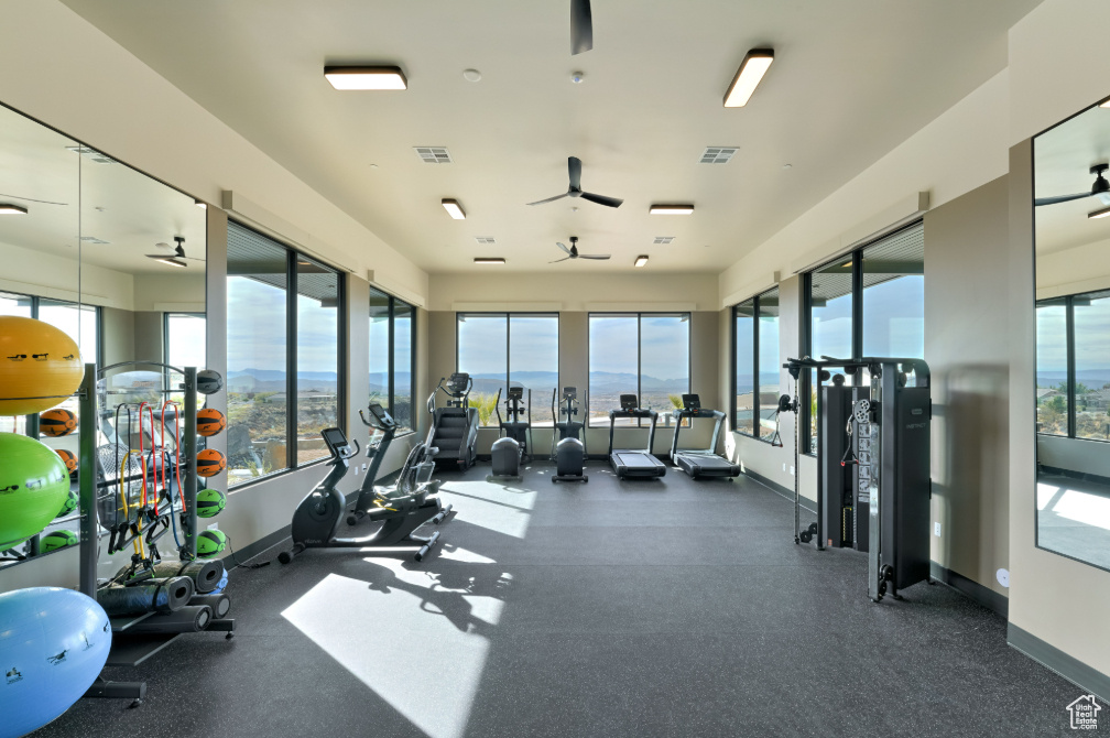 Exercise room featuring ceiling fan, visible vents, and baseboards