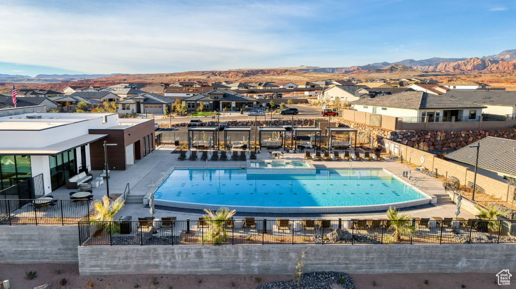 Pool with a mountain view, a residential view, and fence
