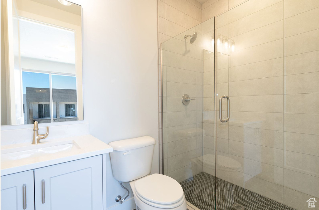 Bathroom with a stall shower, toilet, and vanity