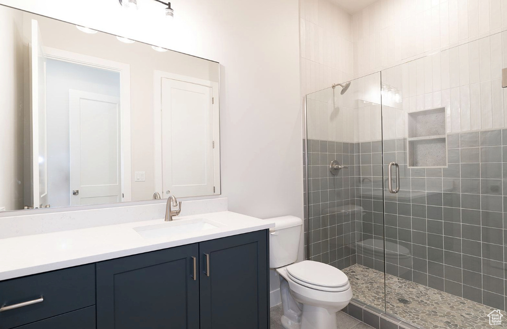 Full bath with vanity, a stall shower, and toilet