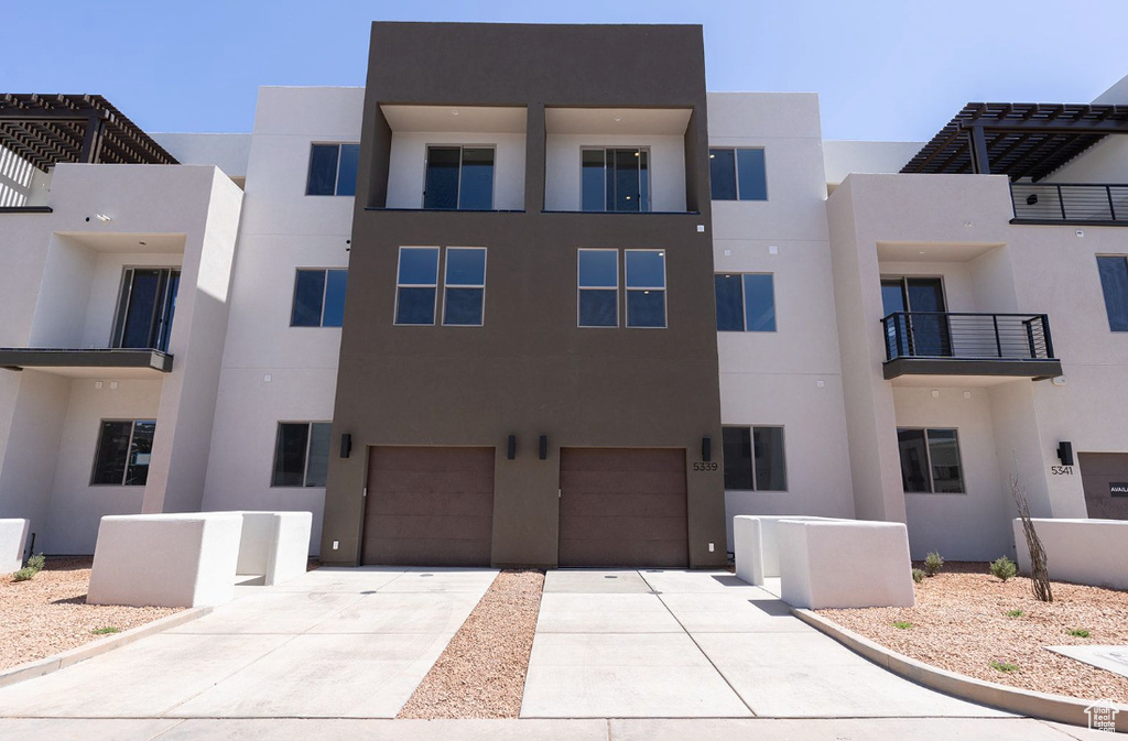 View of building exterior featuring a garage and driveway