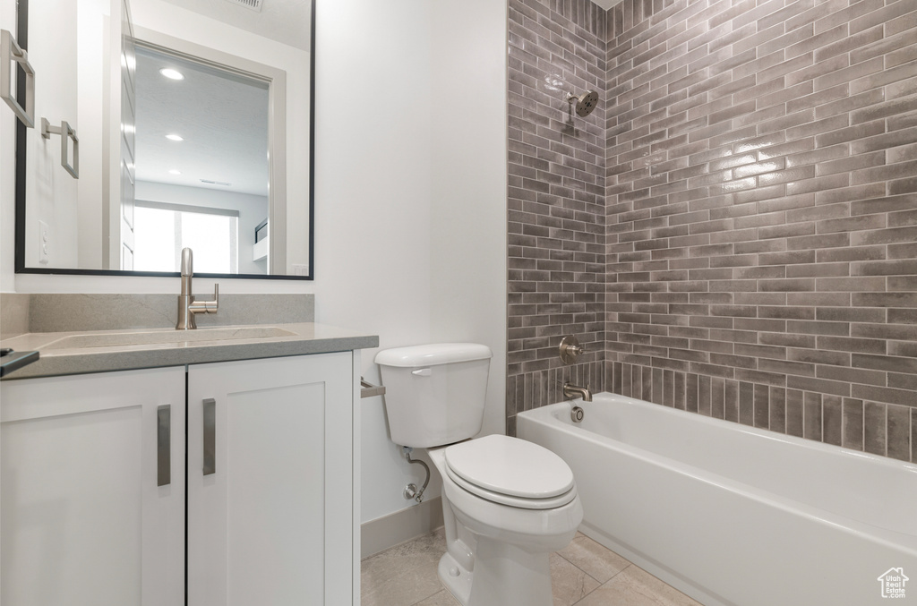 Bathroom featuring vanity, bathtub / shower combination, toilet, tile patterned floors, and baseboards