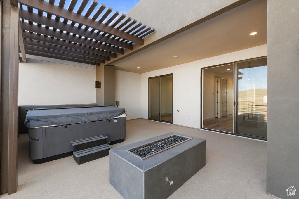 View of patio with a pergola, a hot tub, and an outdoor fire pit
