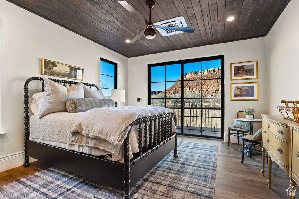 Bedroom featuring wood finished floors, access to outside, recessed lighting, wooden ceiling, and a skylight