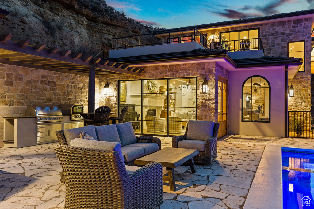 View of patio with a grill, area for grilling, and a balcony