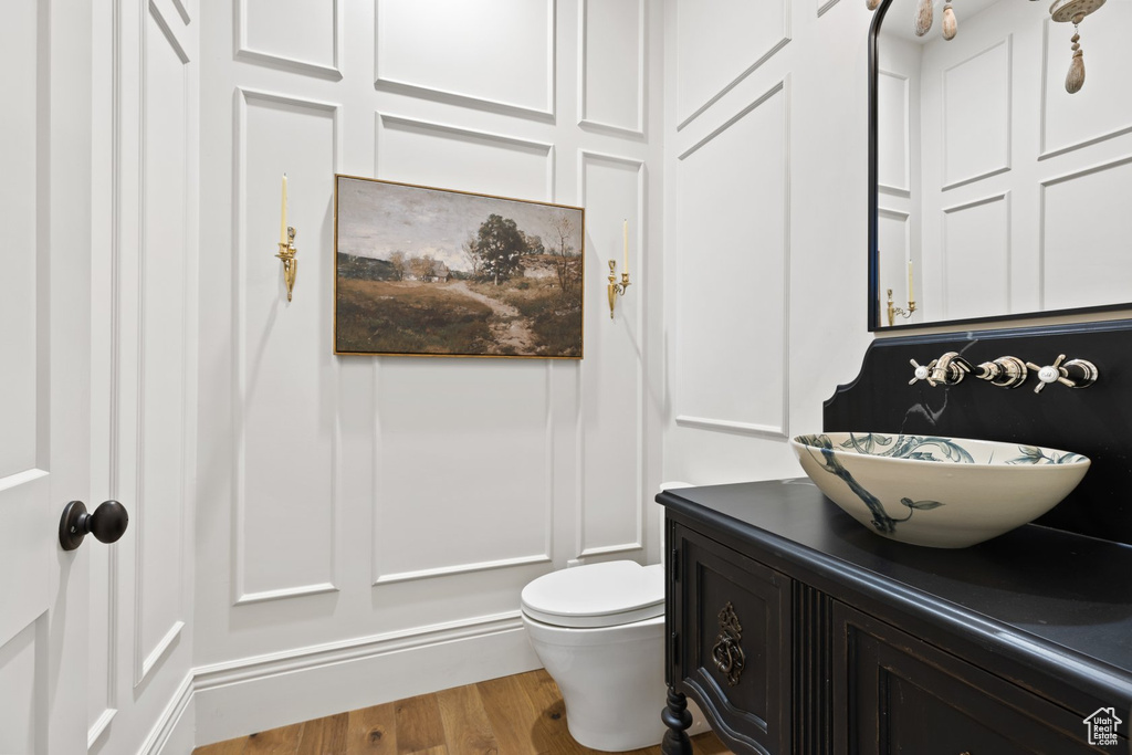 Bathroom featuring vanity, wood finished floors, and toilet