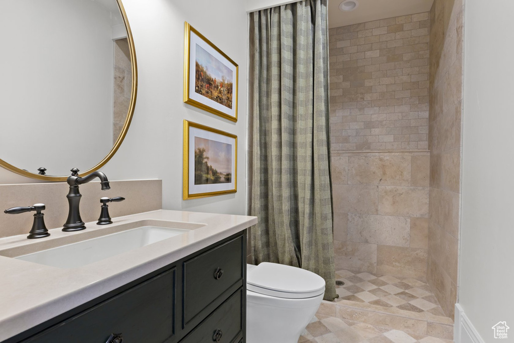 Full bathroom with vanity, a stall shower, and toilet