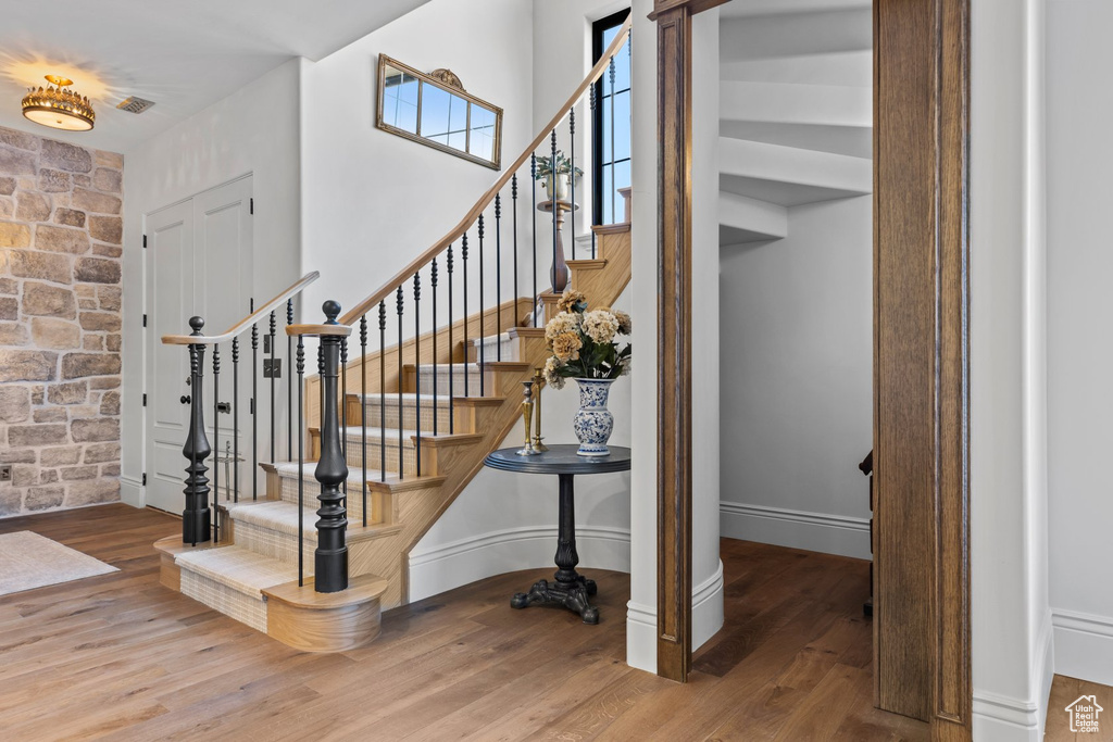 Stairs featuring baseboards, visible vents, and wood finished floors
