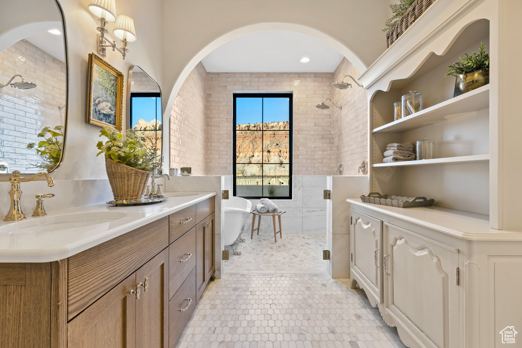 Bathroom with a sink, a freestanding tub, a shower stall, and double vanity