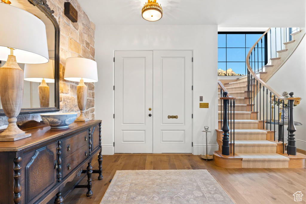 Foyer with stairs, baseboards, and wood finished floors