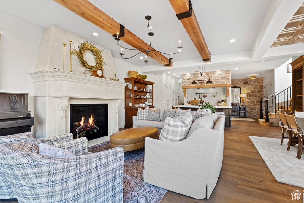 Living area with beam ceiling, a fireplace, stairs, recessed lighting, and wood finished floors