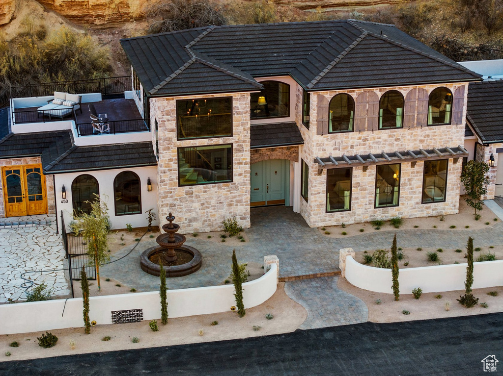 View of front of home featuring stone siding and a balcony