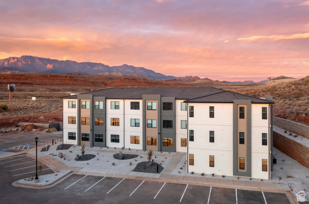 View of building exterior featuring uncovered parking and a mountain view